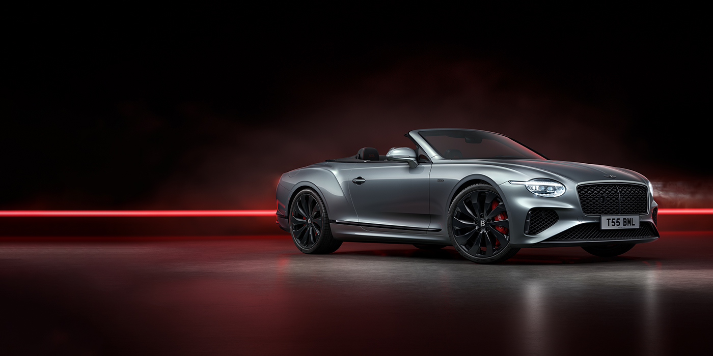 Thomas Exclusive Cars GmbH Bentley Continental GTC Black Edition convertible front three quarters in Hallmark silver against a dark grey and red background