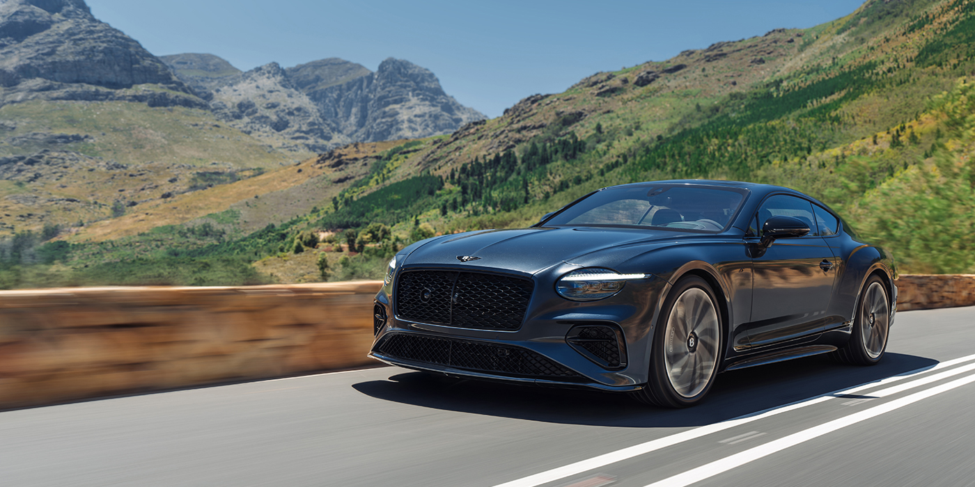 Thomas Exclusive Cars GmbH Bentley Continental GT coupe in Thunder paint and 22" ten swept spoke wheels front 3/4 driving on mountain road