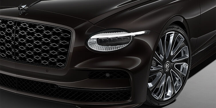 Thomas Exclusive Cars GmbH New Bentley Flying Spur Mulliner sedan head lamp against Havana brown paint with  22" Mulliner Black Painted & Polished wheel