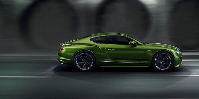  Thomas Exclusive Cars GmbH Bentley Continental GT coupe in Tourmaline Green paint driving in profile on a dark road