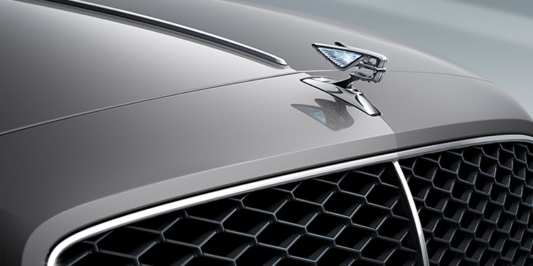 Thomas Exclusive Cars GmbH New Bentley Flying Spur sedan bonnet detail in Silverlake paint with Illuminated Flying B bonnet badge and matrix grille with chrome surround