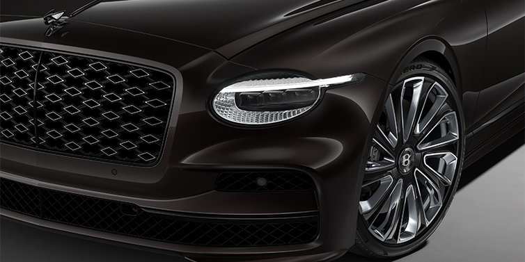 Thomas Exclusive Cars GmbH New Bentley Flying Spur Mulliner sedan head lamp against Havana brown paint with  22" Mulliner Black Painted & Polished wheel